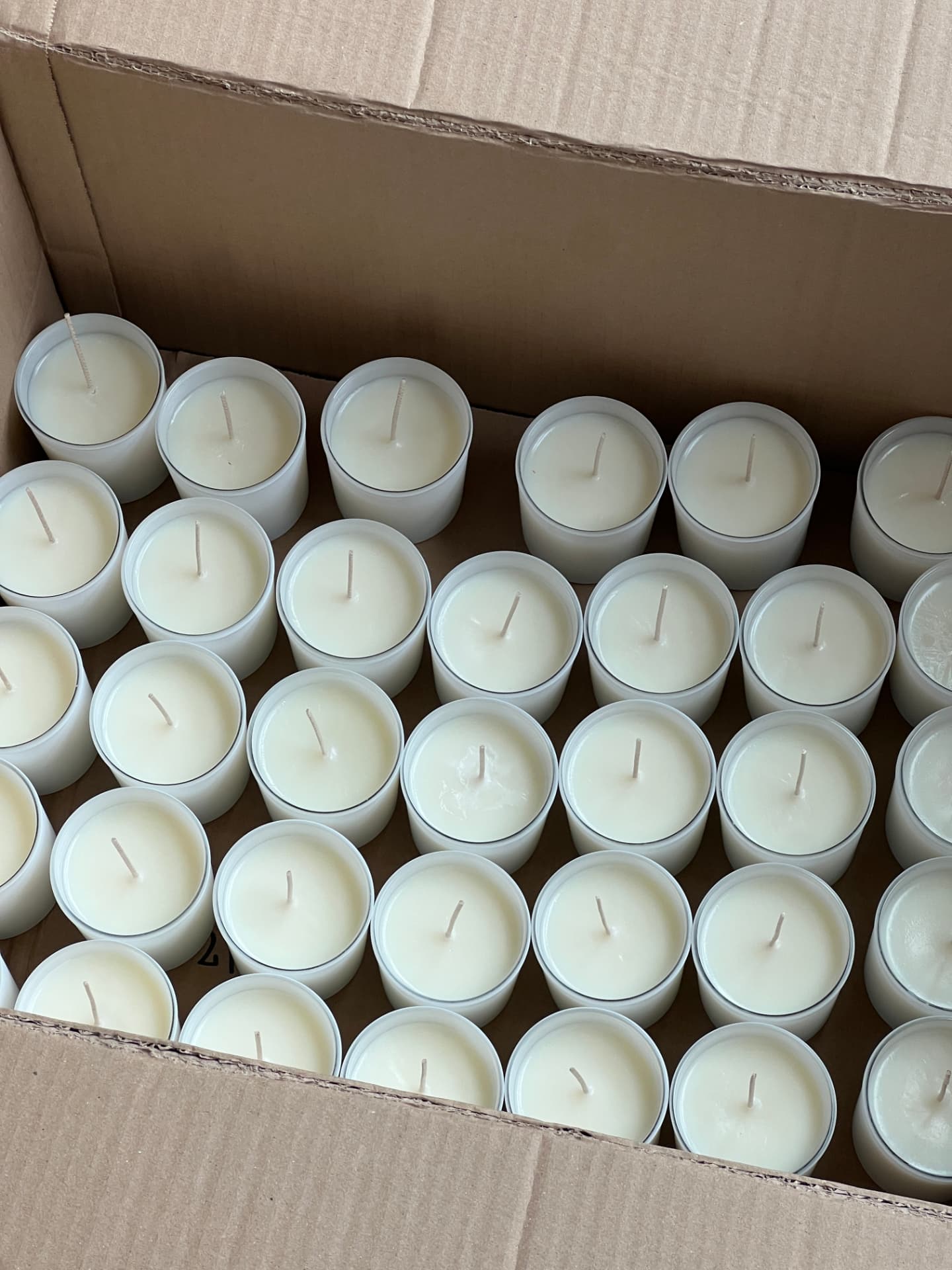 Freshly poured Nida Journey soy candles cooling in a small-batch tray