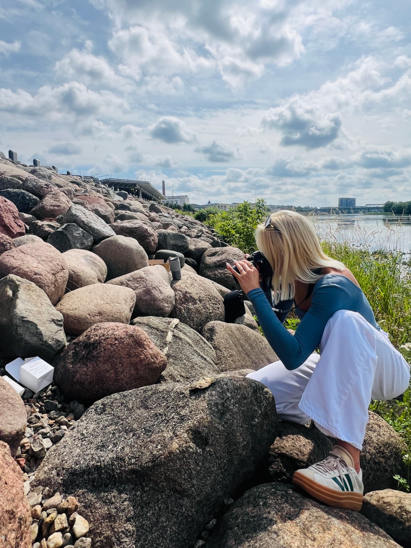 Nida Journey candle being photographed on the riverside boulders in Kaunas